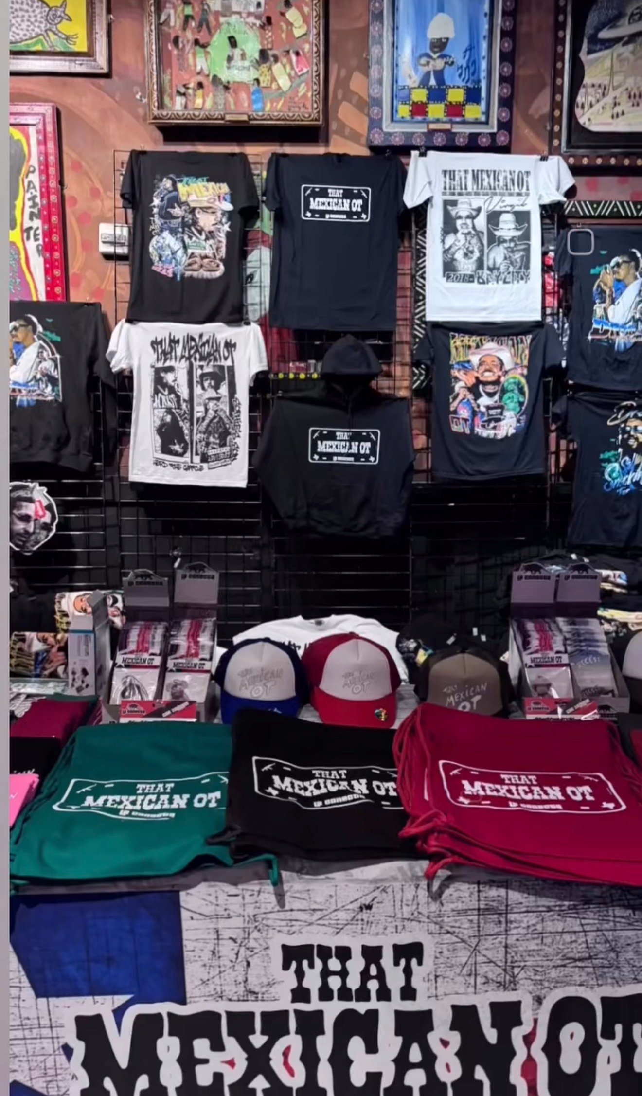Tour merchandise display featuring artist shirts and hats
